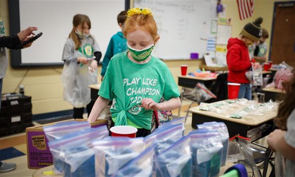 student looks through products on desk